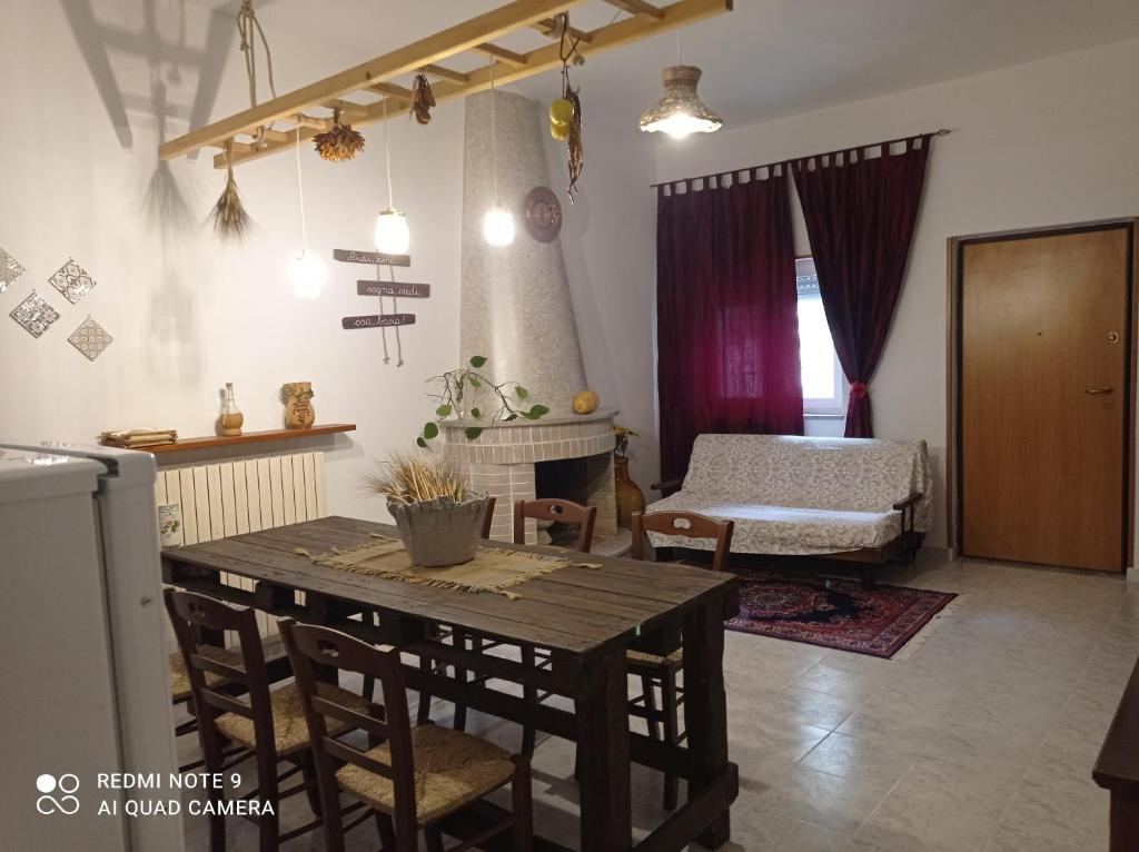 sala de estar con mesa de madera y cama en Casa Tesoro, en Cisternino