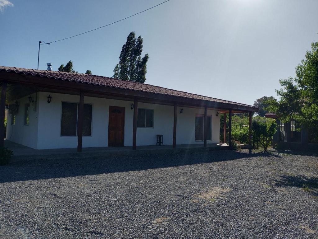 ein weißes Haus mit Kieseinfahrt davor in der Unterkunft Casa de campo en Portezuelo 