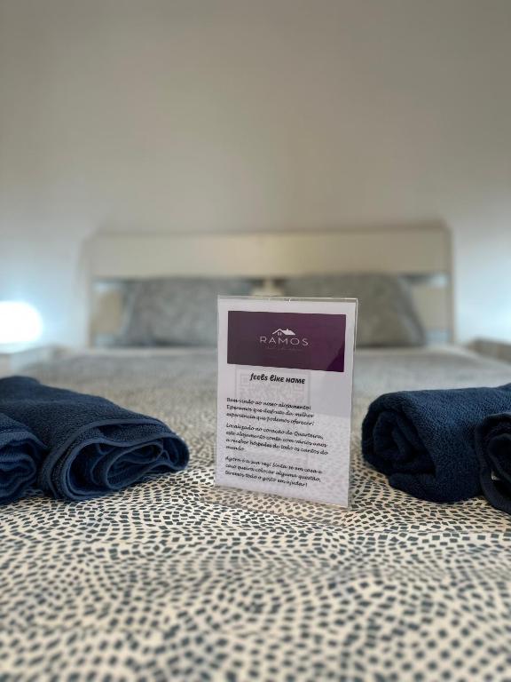 a sign sitting on top of a bed with towels at Alojamento Ramos in Quarteira