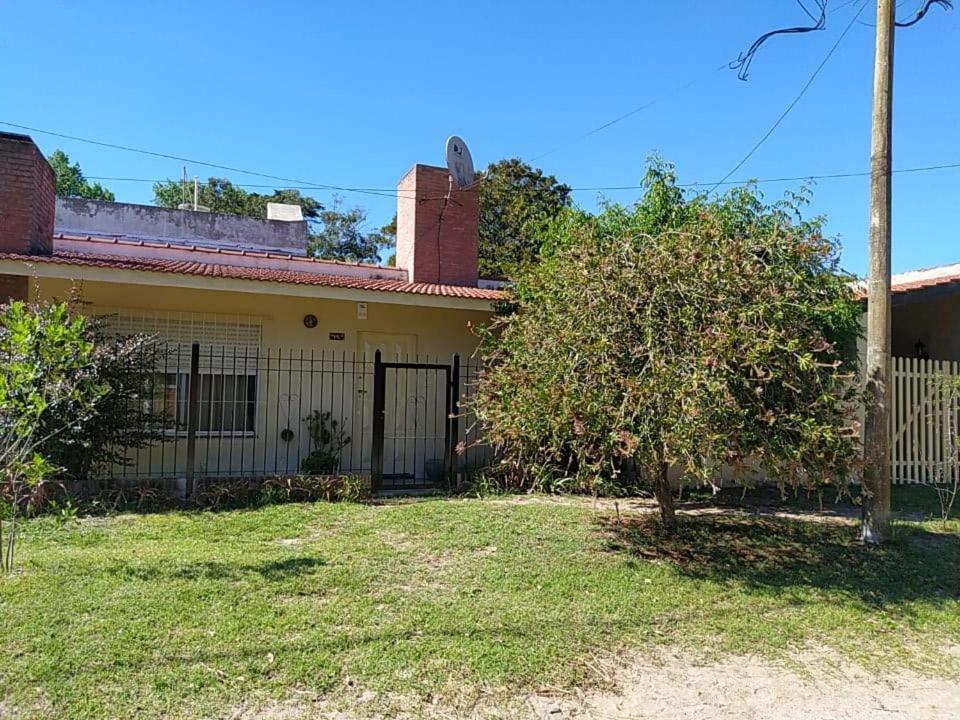 una casa con una valla y un árbol en el patio en Danimar en San Clemente del Tuyú