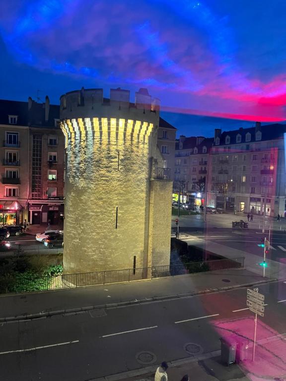 a lit up tower in a city at night at Escapade jacuzzi in Caen