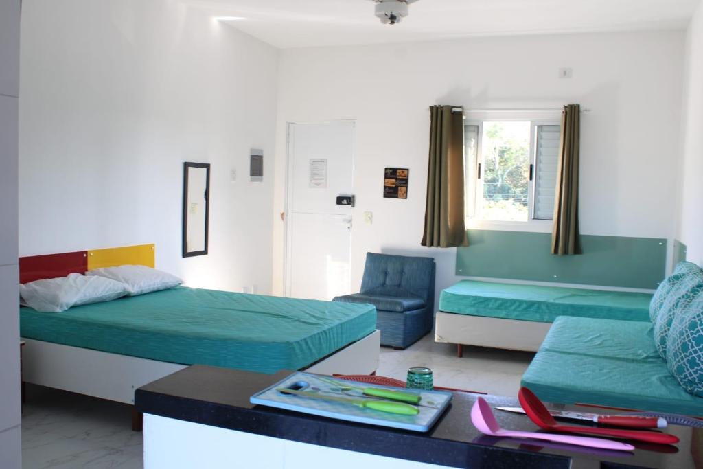 salon z 2 łóżkami i stołem w obiekcie Kitnet Maitinga w mieście Bertioga