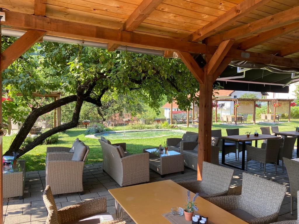 a patio with tables and chairs under a wooden pergola at Motel M in Vlasenica