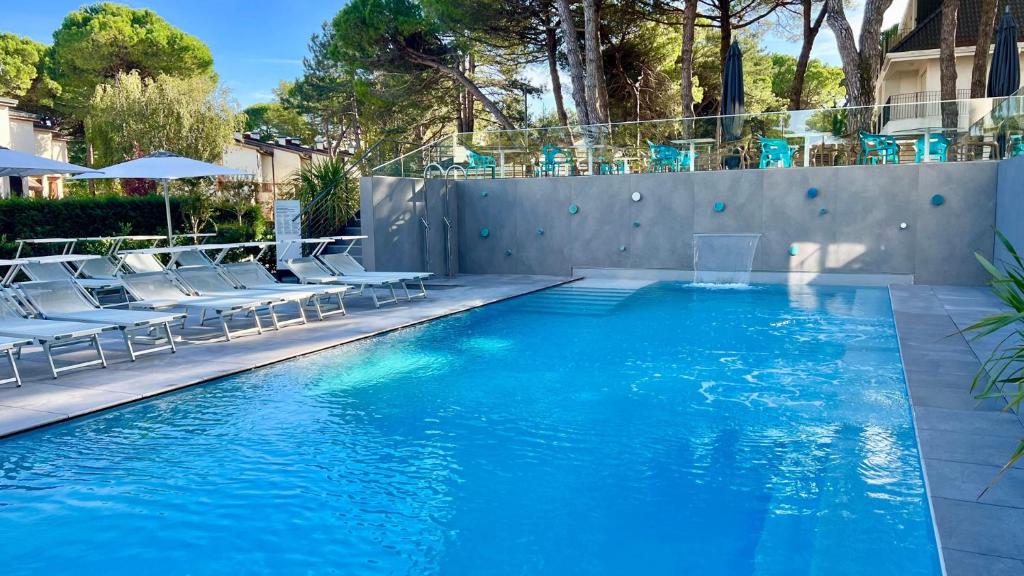 una piscina con sillas y una piscina en Hotel President en Lignano Sabbiadoro