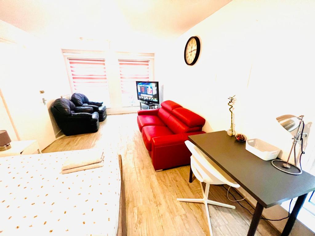 a living room with a red couch and a table at Extra Large Double one Bedroom Rental Near Central London & Close to Transport in London