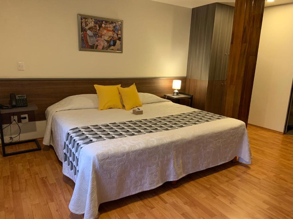 - une chambre avec un grand lit et des oreillers jaunes dans l'établissement Star Suites México, à Mexico