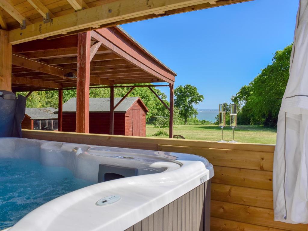 a hot tub in a wooden house with a barn at The Coach House in Wootton Bridge