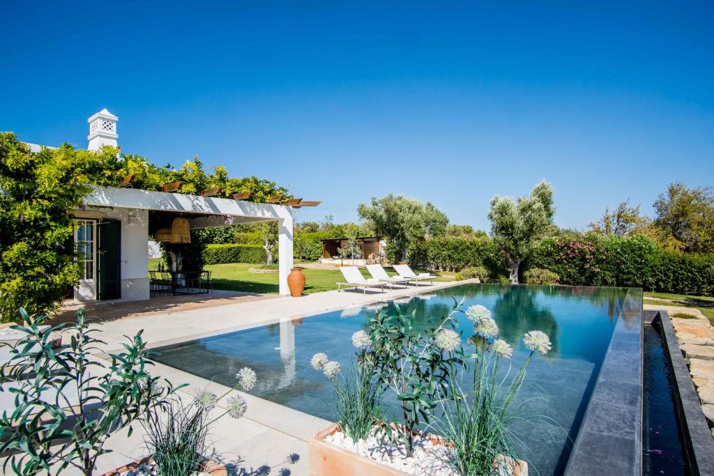 a swimming pool in a backyard with a pergola at Charmante villa Authentique in Loulé