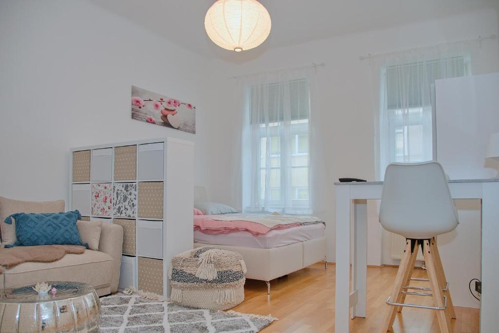 una sala de estar con una cama y una mesa en White Lotus Apartment, en Viena