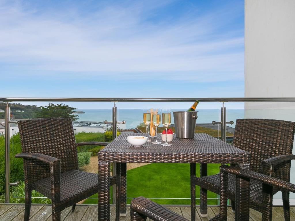 una mesa con una botella de vino en el balcón en Far Cliffs, en St Ives
