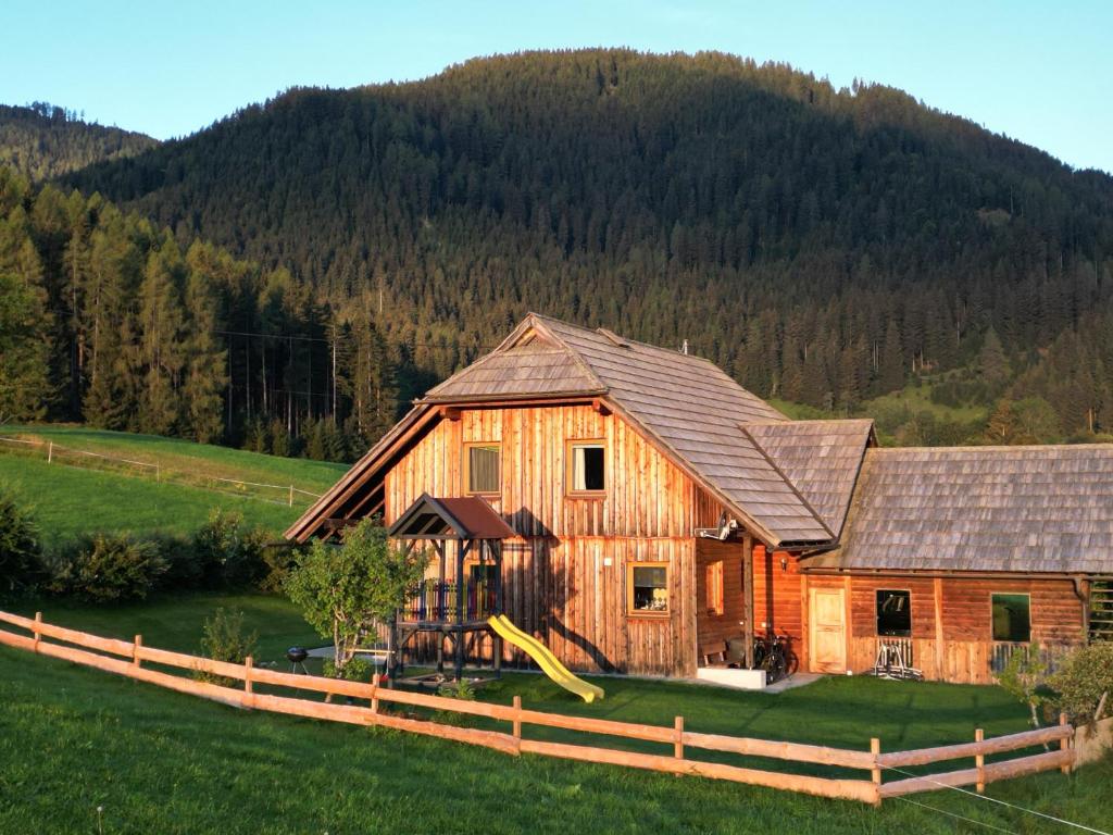 a large wooden house with a slide in front of it at Nagerhof in Gnesau