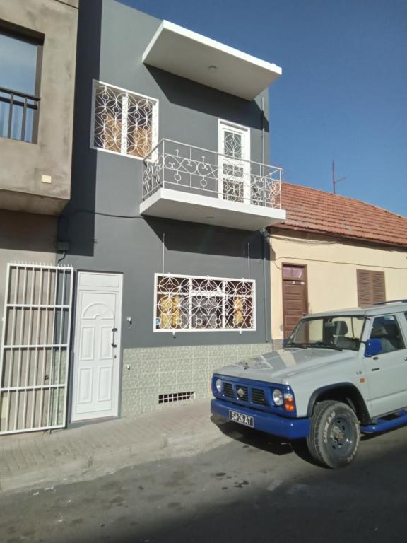 un camion bianco parcheggiato di fronte a una casa di caboverde-houses a Mindelo