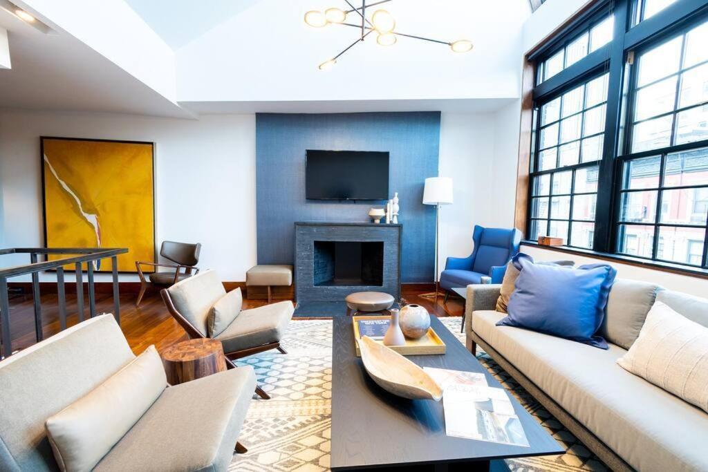 un soggiorno con divano e camino di E10-3 3BR Designer Townhouse a New York