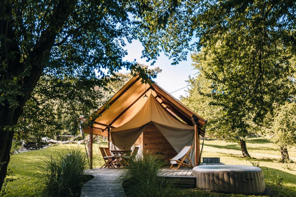 a tent with chairs and a table in a field at Luxury vineyard resort Chateau Ramšak in Maribor