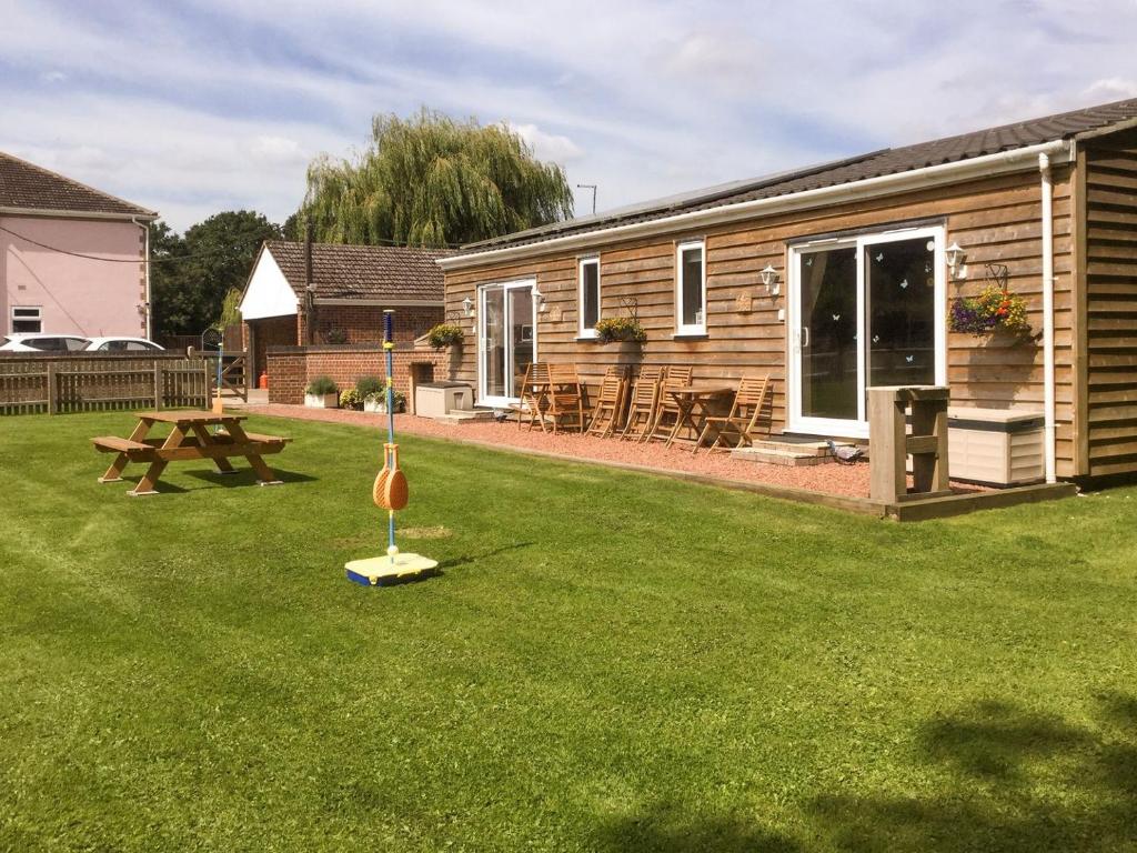 a backyard with a log cabin and a picnic table at Squirrels Drey in North Walsham