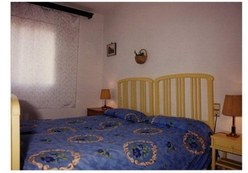 a bedroom with a bed with a blue comforter and two chairs at Mar De Cunit in Cunit