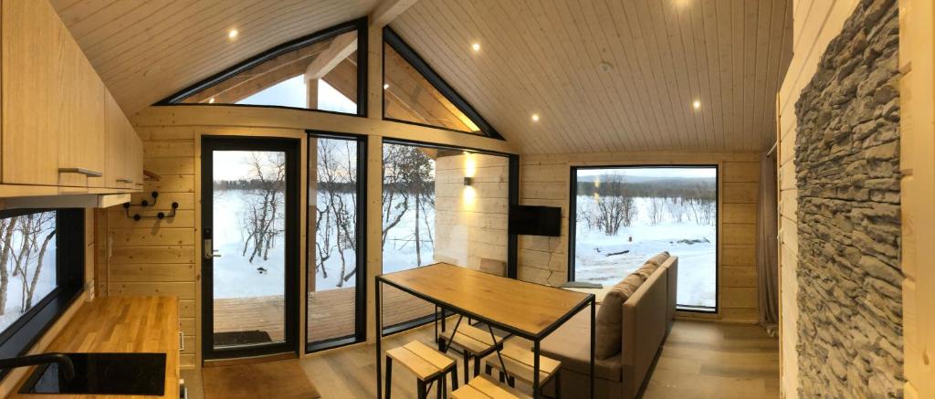 a dining room with a table and some windows at Chalet Luokta in Inari
