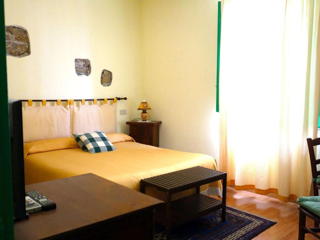 a bedroom with a bed and a table in it at Bed and Breakfast Sorriso in Taormina