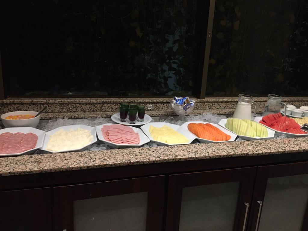 a counter with many different types of cheeses on them at Pousada dos Girassóis in Palmas