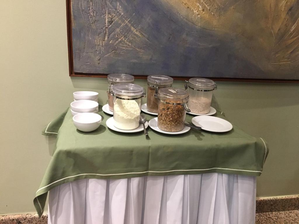 a table with jars and plates of food on it at Pousada dos Girassóis in Palmas