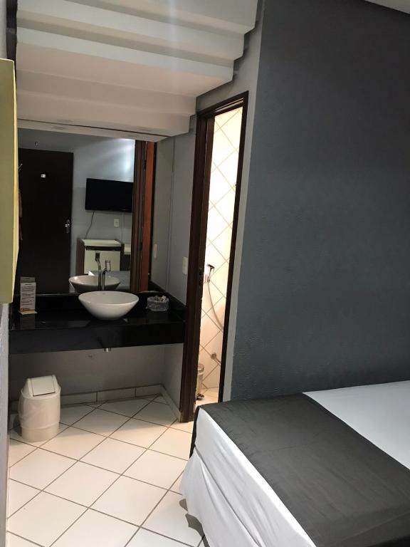 a bathroom with a sink and a mirror at Pousada dos Girassóis in Palmas