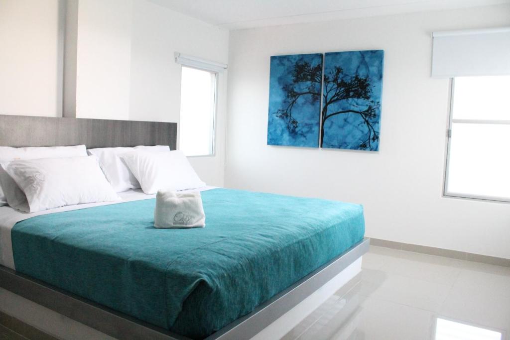 um quarto com uma cama com um cobertor azul em Onix Hotel em Neiva