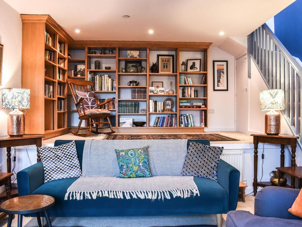 un soggiorno con divano blu e librerie di Linstead House a Kendal