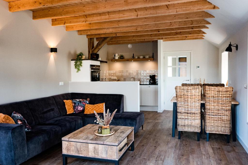 a living room with a couch and a table at Landelijk gelegen vakantiewoning in Oldebroek