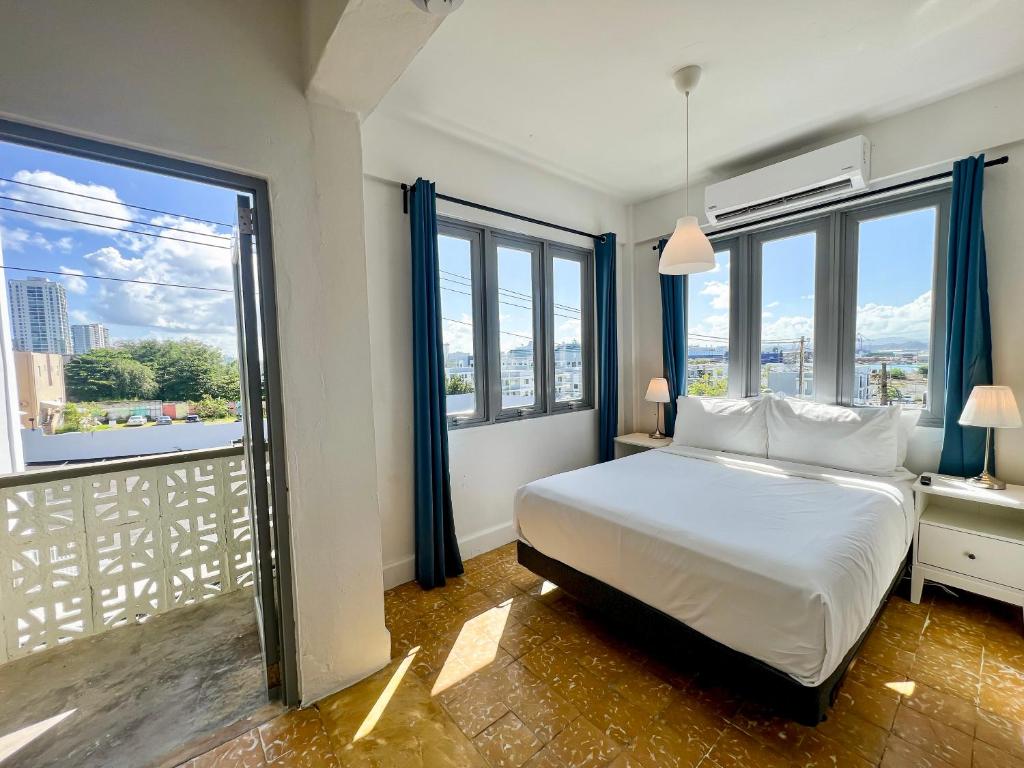 a bedroom with a bed and large windows at Urbana Hotel in San Juan