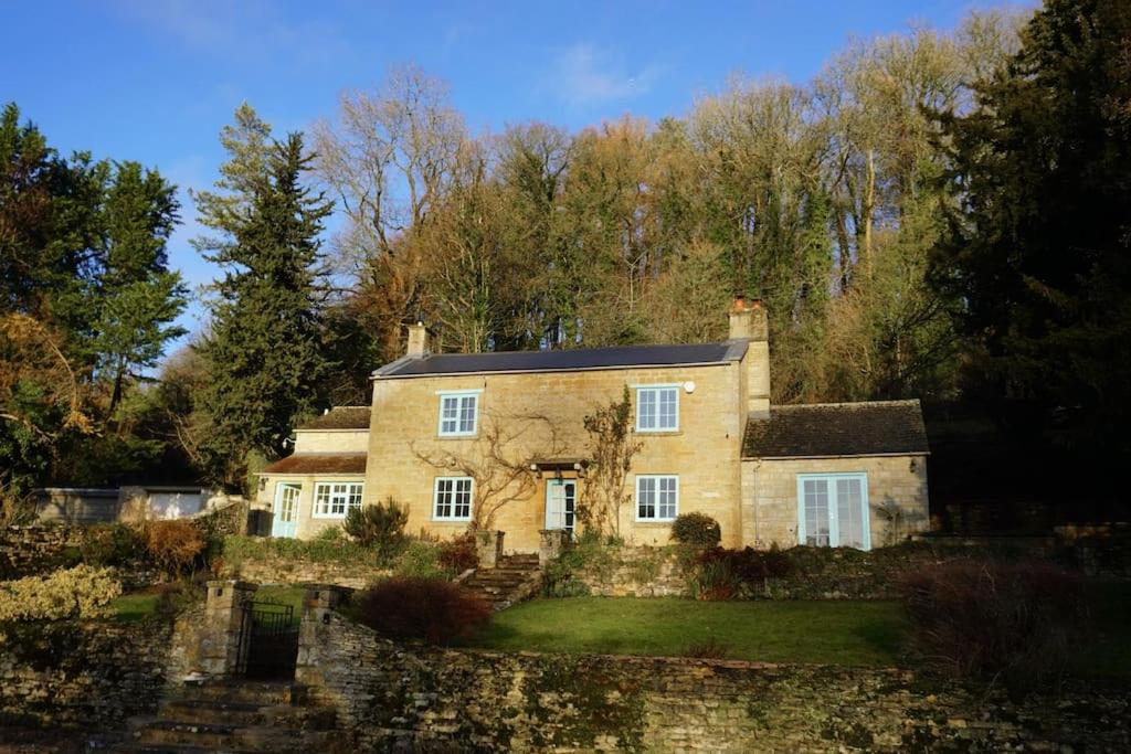 The Snicket - Traditional Cotswold Home في تشلتنهام: بيت حجري كبير وفيه اشجار في الخلف