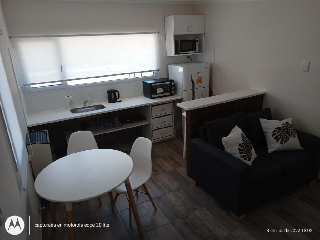 una pequeña cocina con mesa y sofá en una habitación en Junin en Coronel Suárez