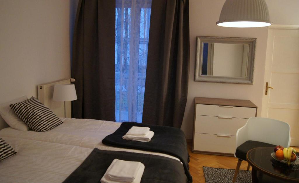 a bedroom with a bed and a table and a mirror at Apartament Daszyńskiego in Krakow