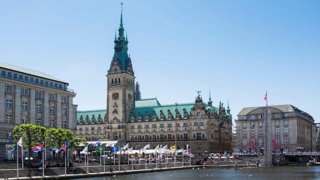 un grand bâtiment avec une tour d'horloge en face dans l'établissement Holiday Inn Hamburg - City Nord, an IHG Hotel, à Hambourg