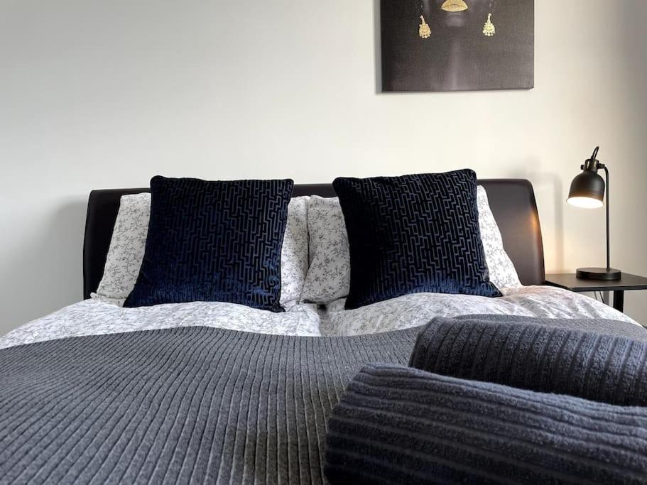 Una cama con dos almohadas azules encima. en Newly refurbished 3 bedroom entire terraced house, en Lincolnshire