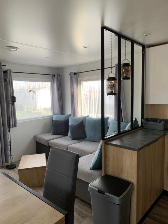 een woonkamer met een bank en een spiegel bij Oostkapelle Chalet JD 56 In de Bongerd in Oostkapelle