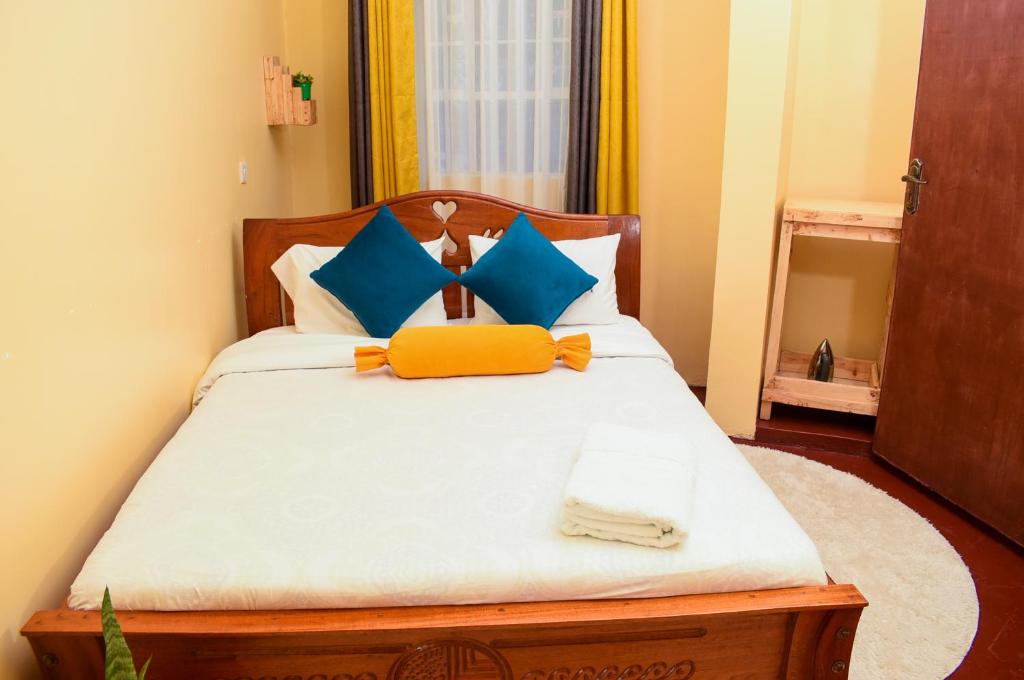 奈瓦沙的住宿－Naivasha Southlake apartments，一间卧室配有蓝色和黄色枕头的床