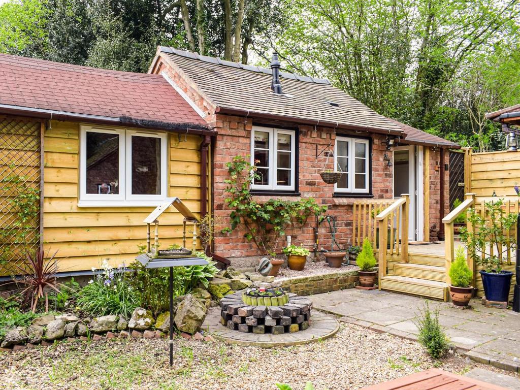 a small house with a garden in front of it at Woodcarvers Cottage in Dawley