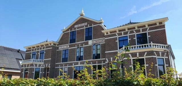 een groot bakstenen gebouw met ramen aan de zijkant bij Bed and Breakfast Geliefd in Voorhout