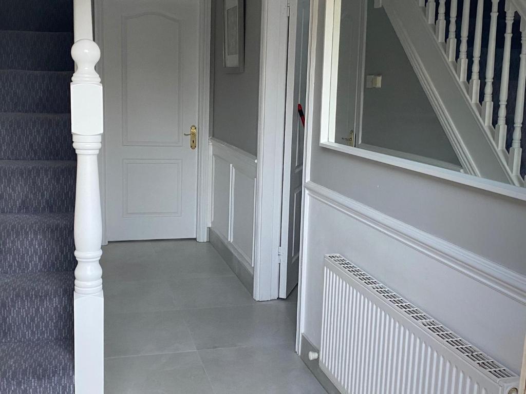 un pasillo con una puerta blanca y una escalera en Modern house in Dublin en Dublín