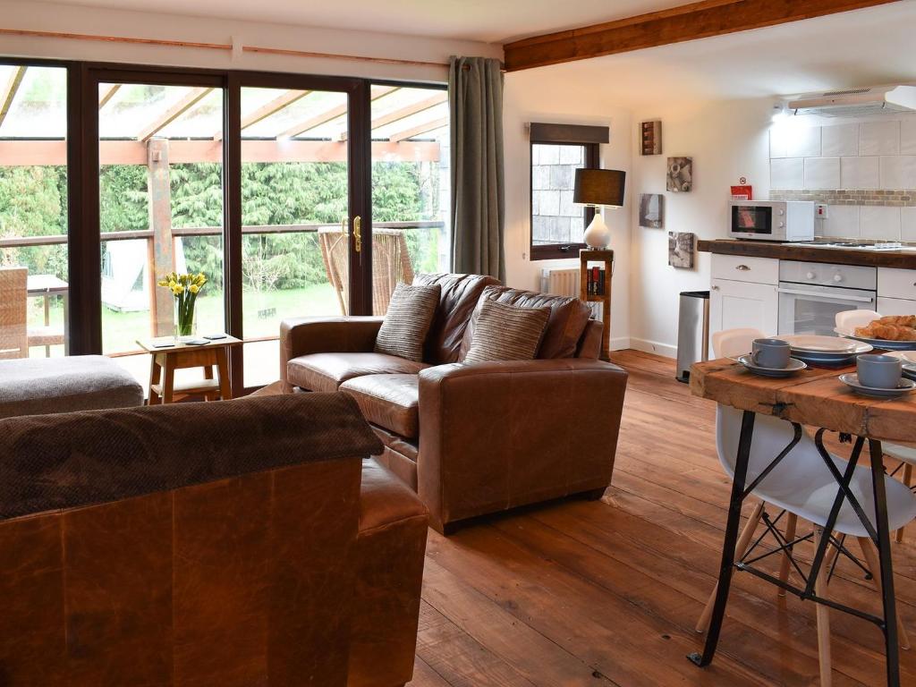 a living room with two couches and a table at The Wood House in Buckfastleigh