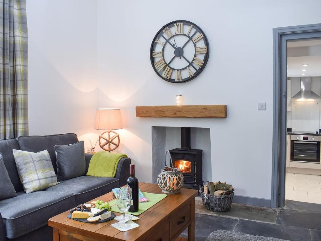 a living room with a couch and a clock on the wall at Cilwendeg Lodge in Newchapel