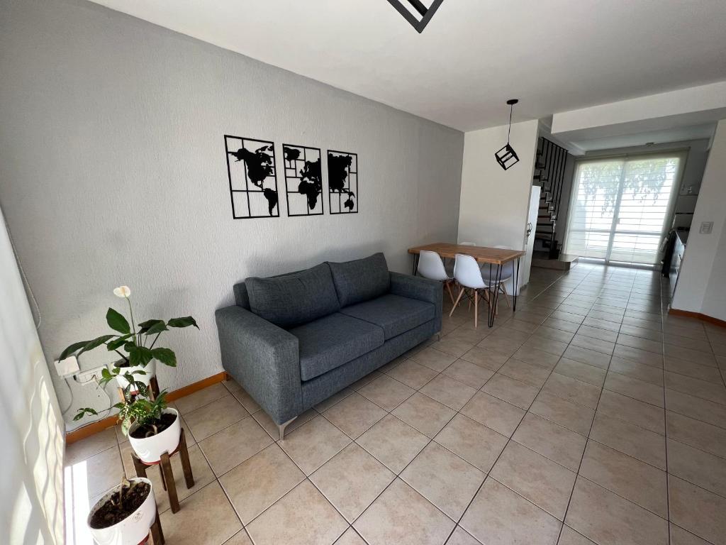 ein Wohnzimmer mit einem blauen Sofa und einem Tisch in der Unterkunft Hermoso duplex con estacionamiento in Guaymallen