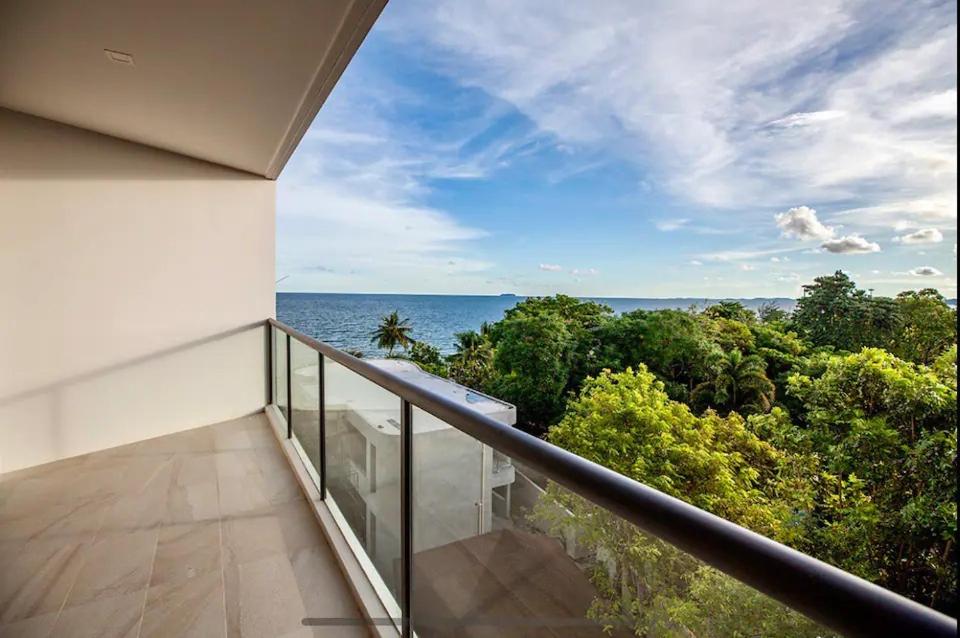 a balcony with a view of the ocean at Mae Phim Escape Beachfront Apartments in Mae Pim
