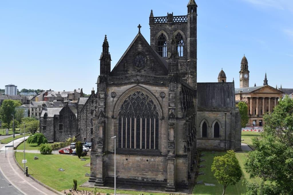 uma velha igreja numa rua numa cidade em THE PAISLEY PENTHOUSE - ABBEY VIEW em Paisley