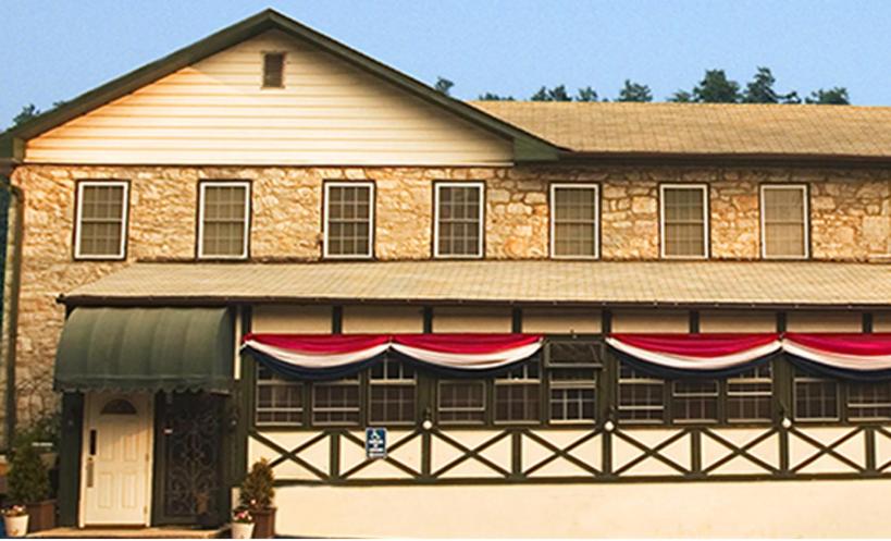 d'un grand bâtiment en briques arborant des drapeaux rouges et blancs. dans l'établissement Mountain Creek Tavern, 
