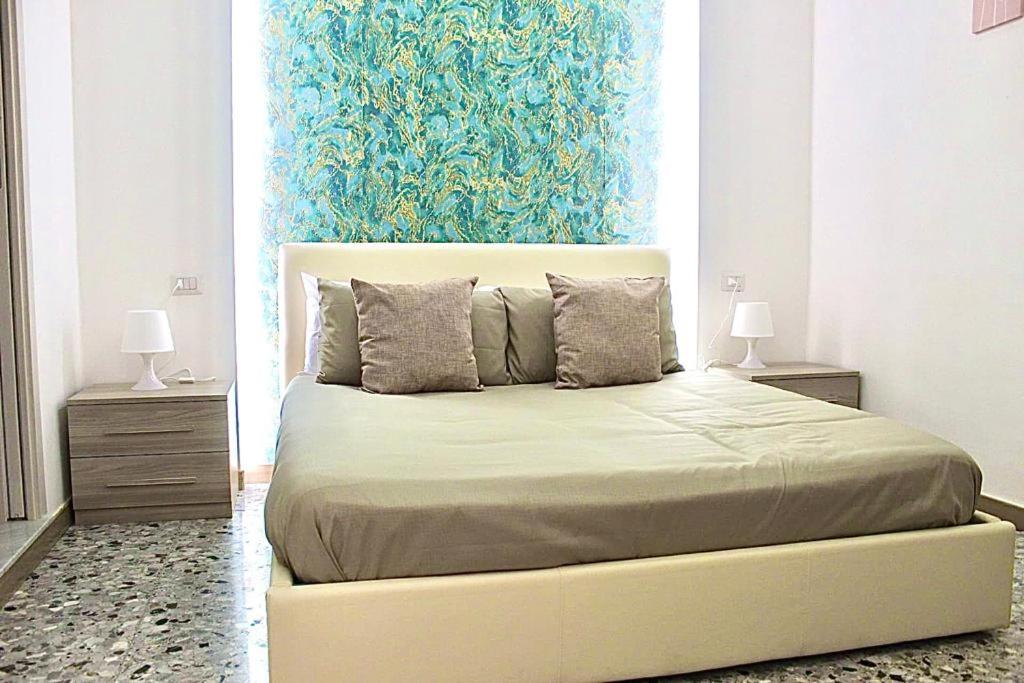 een slaapkamer met een bed met een blauw schilderij aan de muur bij Suite Pompeii in Pompei