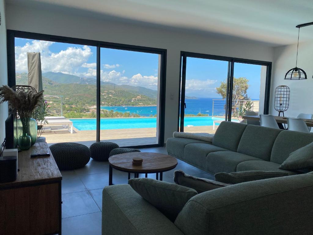 ein Wohnzimmer mit Couch und Blick aufs Meer in der Unterkunft Villa Pura Corsica with sea view and private pool in Conca