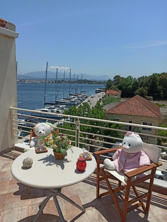 deux animaux farcis sont assis dans des chaises sur un balcon dans l'établissement AB Preveza Seaside Attic Sofita -15 Meters Over the Sea, à Prévéza