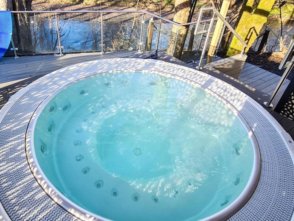 a hot tub with blue water inside of it at Dalgarven Spa House in Dalry