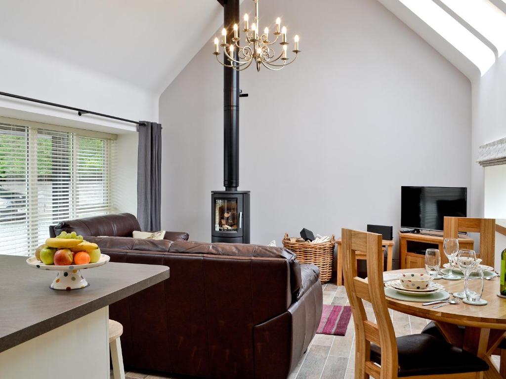 a living room with a brown couch and a table at Longcroft Dairy in Oyne